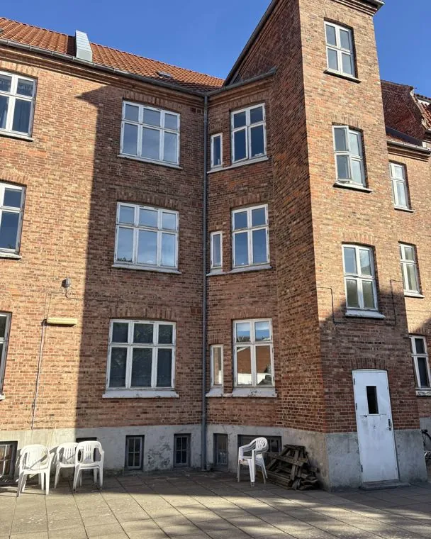 Ejendommens gamle, nedslidte vinduer før udskiftning
